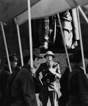 Soldat der Nationalen Volksarmee und fahnentragende Kampfgruppen am "Tag der Befreiung" am Sowjetischen Ehrenmal