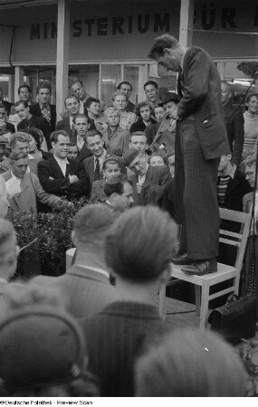 Besucher betrachten eine Vorführung vor dem VEM-Pavillon der Leipziger Herbstmesse 1954
