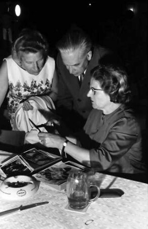 12. Tagung 1962 Physik; Studentenabend beim Tanz: Ehepaar Segrè betrachtet Praghr-Fotos