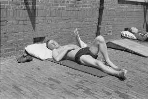 Zweiter Weltkrieg. Niederlande unter deutscher Besatzung. Angehöriger der deutschen Wehrmacht vor der Unterkunft beim Sonnenbaden (wohl bei Den Haag)