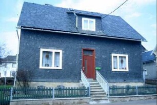 kleines Wohnhaus mit Treppenaufgang und Vorgarten