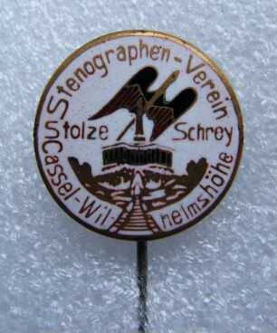 Vereinsabzeichen Stenographen-Verein Stolze-Schrey Cassel-Wilhelmshöhe (mit langer Nadel) : Sammlung Beinhorn. Vereinsabzeichen Stenographen-Verein Stolze-Schrey Cassel-Wilhelmshöhe (geflügelte Feder und Herkules auf weißem Grund, Umschrift "Stenographen-Verein Stolze-Schrey Cassel-Wilhelmshöhe", mit langer Nadel). Email, Metall; Durchmesser 21 mm (um 1921). Dresden: SLUB R c 0280