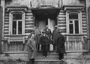 Gruppenbildnis, Männer auf der Eingangstreppe eines Holzhauses