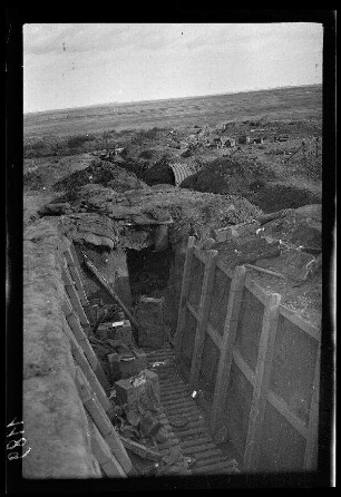 Zwischen Bapaume und Arras (beide Dep. Pas-de-Calais, Frankreich): Schützengraben mit Bohlenweg und verlassener (?) Munition (Blick vom Grabenrand) ("Stellungen")