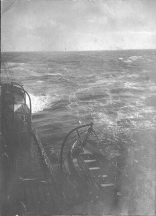 Gischt der Heckwelle eines Schiffes. Blick von einem Oberdeck auf Achterschiff mit Rettungsboot an Davits