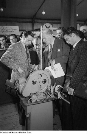 Besucher der Leipziger Herbstmesse 1954 bei der Vorführung einer Maschine