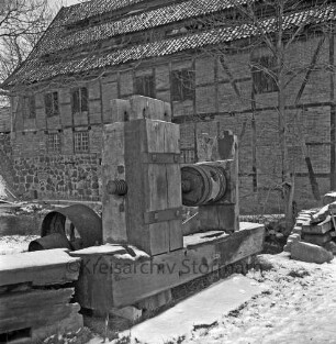 Drahtmühle: Restaurierung: vorn Mühlenwerk der Papiermühle mit Holzbohlen: rechts Stapel mit Bretternund Baum: Winter