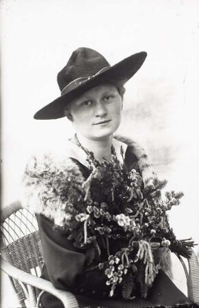 Hulda Hanisch (Ehefrau des Fotografen) mit breitkrempigem Hut, Pelzkragen und Weidenkätzchenstrauß