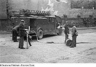 Aufnahmen der Feuerwehr Berlin bei Rettungsübungen : Feuerwehrleute mit Löschfahrzeug