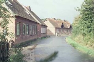 Alte Dorfstraße 5, 7, 9 [von links]: ehemalige Gutsarbeiterkaten, rechts Mehrfamilienkate aus Backstein: traufständige Straßenfronten