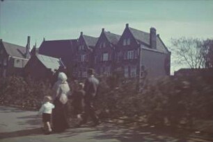 Reisefotos. Straßenbild mit Familie. Im Hintergrund Backsteinhäuser (vielleicht in Holland)