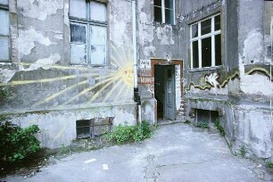 Berlin-Mitte, Brunnenstraße. Hinterhof. Eingang in ein marodes Gebäude mit Graffiti (Sonne, Beschriftung "Haus Hoffnung" und "Herzlich willkommen, alle freundlichen Leute" u.a.)