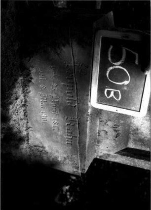 Grabstein 50 (Index: 100109994) Material: Sandstein Zustand: im Sockel gebrochen, verwittert Maße HxBxT: 130x47x17 cm Beschreibung: Stele, getreppter Sockel, eingezogener Rundbogenabschluß mit Verdachung, Schriftfeld eingetieft Besonderheit: auf Rückseite eingravierte Nr.: 93: Grabstein 50B