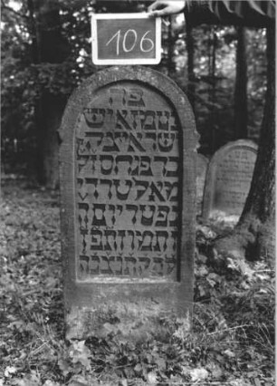 Grabstein 106 (Index: 99894953) Material: Sandstein Zustand: sehr gut Maße HxBxT: 115x54x12 cm Beschreibung: Stele mit Rundbogenabschluss Besonderheit: kulturhistorisch wertvoll / hist.-wiss. Gründe: Grabstein 106