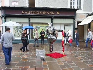 Salzburg - Straßenkünstler als "Mozart" : Ein als "Mozart" verkleideter Straßenkünstler "schwebt" vor dem Gebäude der Raiffeisenbank am Residenzplatz. Aufgenommen in Salzburg am 22. Juli 2011