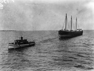 Eisentransportschiff mit Schlepper auf dem Oberern See : Blick auf ein von einem Schleppschiff gezogenes Schiff