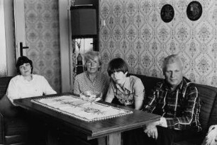 Familie F. (Lohnbuchhalterin, Montagemeister, Töchter: Ingenieurin, Vorpraktikantin) im Wohnzimmer