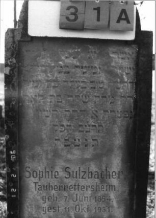 Grabstein 31 (Index: 100116129) Material: Sandstein Zustand: verwittert mit teilweisem Textverlust Maße HxBxT: 133x49x22 cm Beschreibung: doppelt aufgesockelte Stele mit eingezogenem Runbogenabschluß und eingetieftem Schriftfeld: Grabstein 31A (Detailaufnahme 2)