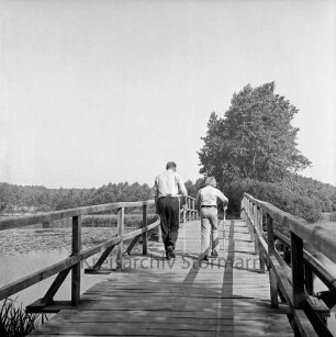 Herrenteich: Fischhuser Damm: hölzerne Fußgängerbrücke: Mann, Junge mit Stöcken auf Brücke: Blick Richtung Norden
