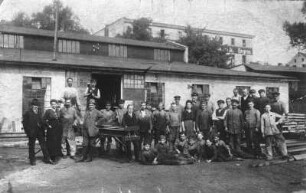 Sprottau. Belegschaft eines metallverarbeitenden Betriebes. Gruppenaufnahme vor einer Werkhalle