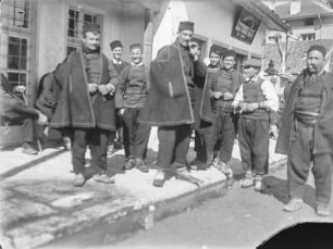 Gruppenportrait : Gruppenportrait mehrerer Männer auf einer Straße.
