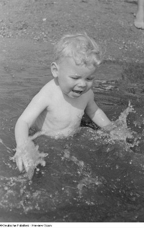 Kleiner Junge, im Wasser planschend