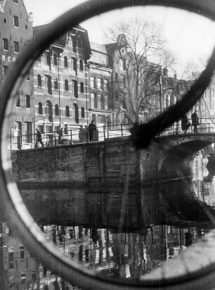 Niederlande. Amsterdam. Blick auf eine der vielen Grachten der Stadt. Eine Brücke überspannt den Kanal.