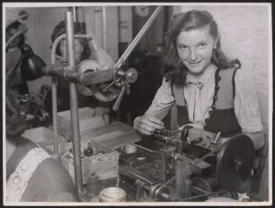 Frau an einer feinmechanischen Werkzeugmaschine