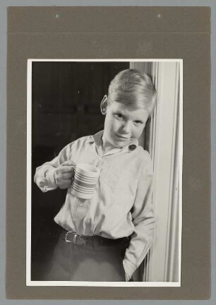 Portrait eines Jungen in Hemd mit Tasse