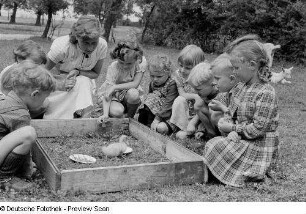 Kinder beim Beobachten eines Entenkükens