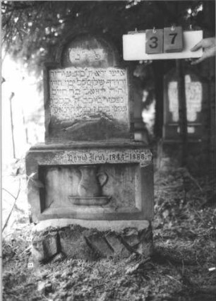 Grabstein 37 (Index: 99800316) Material: Sandstein Zustand: Sockel, der nicht zur aufgesetzten Stele gehört Beschreibung: getreppter Sockel, unten rusticaartig Besonderheit: wahrscheinlich gehört der Sockel zu der Stele Nr. 20A: Grabstein 37