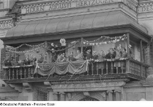 Karnevalsteilnehmer auf dem Balkon des Alten Rathauses