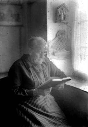 Frau bei Lektüre am Fenster