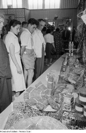 Besucher mustern Ausstellungsstücke der indischen Sektion auf der Leipziger Herbstmesse 1954