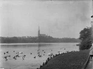 Stadtteilansicht über ein Gewässer mit Uferpromenade