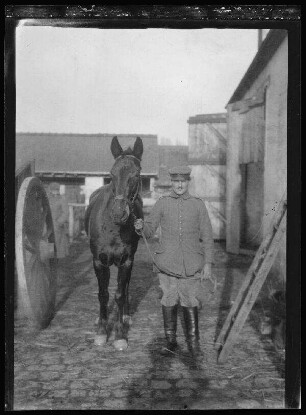 Pferd und Bursche des Oberleutnants Knorr in einem Dorf