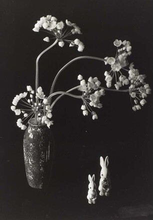 Arrangement mit Blütendolden in Keramikvase und zwei Keramikosterhasen