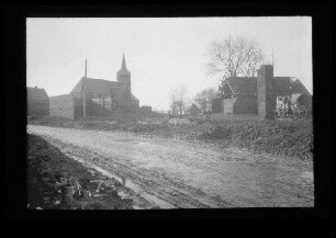 Bus (Dep. Pas-de-Calais, Frankreich): "Kirche von der Seite", im Vordergrund morastige Ortsstraße und Gebäuderuine (Distanzaufnahme)