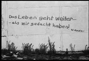 Mauer mit Inschrift "Das Leben geht weiter - als wir gedacht haben"