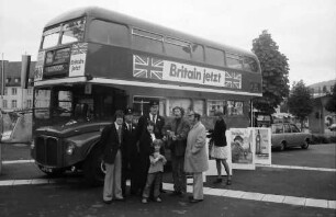 Freiburg: London-Bus auf Tournee am Karlsplatz, mit Singgruppe