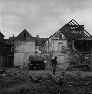 Firma Carl Hoffmann: Hindenburgstraße: Elektrohandel: Abriss der alten Gebäude: Rückfront: vorn Arbeiter und Hund zwischen Balken: hinten Mitte Lkw: hinten rechts Bagger: dahinter teilweise abgerissene Gebäude: 24. Mai 1968