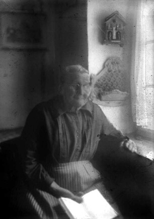 Frau bei Lektüre am Fenster