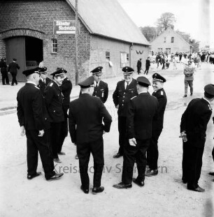 Neritz: Amtsfeuerwehrfest: Dorfstraße: Besprechung des Kreisfeuerwehrvorstands mit Kreisbrandmeister Hinrich Harms: hinten Scheune und Bauernhaus: hinten rechts Zuschauer