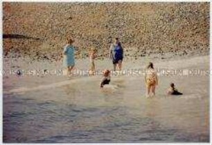 Badende Familie am Strand (Altersgruppe bis 14)