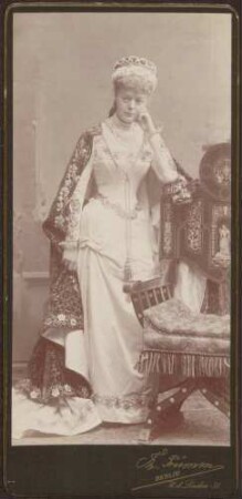 Damenporträt mit Kostüm einer Edeldame mit Cape und Hut.