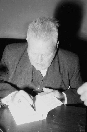 Freiburg: Der Dichter Wilhelm von Scholz sitzend, schreibt