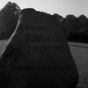 Matthias-Claudius-Gedenkstein: Grünanlage vor Matthias-Claudius-Schule: mit Inschrift "Unserem Matthias Claudius 5.8.1740 - 21.1.1815"