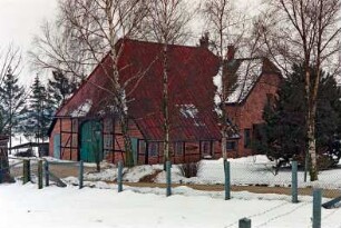 Langniendorf: Steinkoppel 3: traufständiges Bauernhaus aus Fachwerk: links Wirtschaftstrakt, Giebelseite mit Scheunentor: rechts Querbau Wohntrakt: Hofeinfahrt, Zäune, Bäume: Schnee