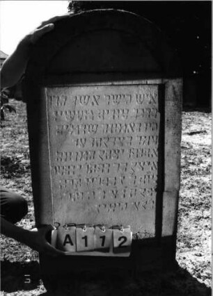 Grabstein 112 (Index: 99798107) Material: Sandstein, rot Zustand: leicht verwittert Maße HxBxT: 117x61x14 cm Beschreibung: Stele, Segmentbogenabschluß: Grabstein 112A