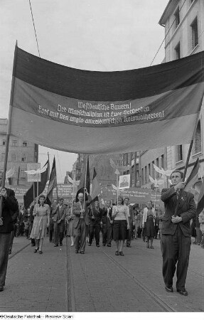 Teilnehmer einer Demonstration mit Spruchbannern, Friedenstauben und einem Bildnis Stalins in der Grimmaischen Straße